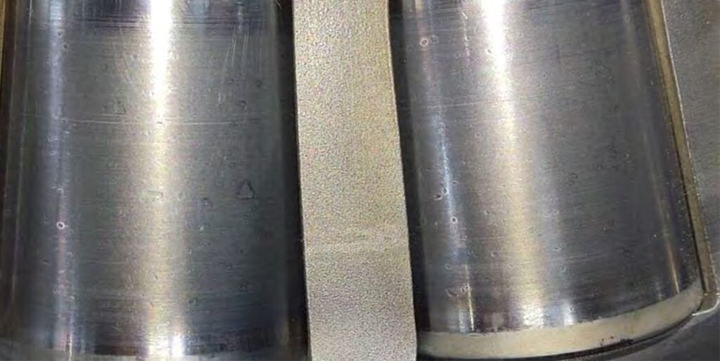 Marks on the outer race from excessive axial pressure on the bevel shaft housing cover. Chipping of the roller and outer race surfaces. Numerous dents on the roller and race surfaces.