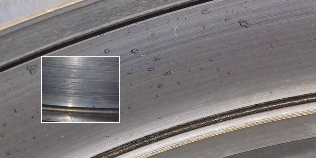 Peeling of roller surfaces, inner and outer races. Numerous dents on roller and race surfaces.